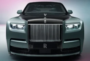 Тёмный Rolls-Royce припаркован на газоне у исторического здания
