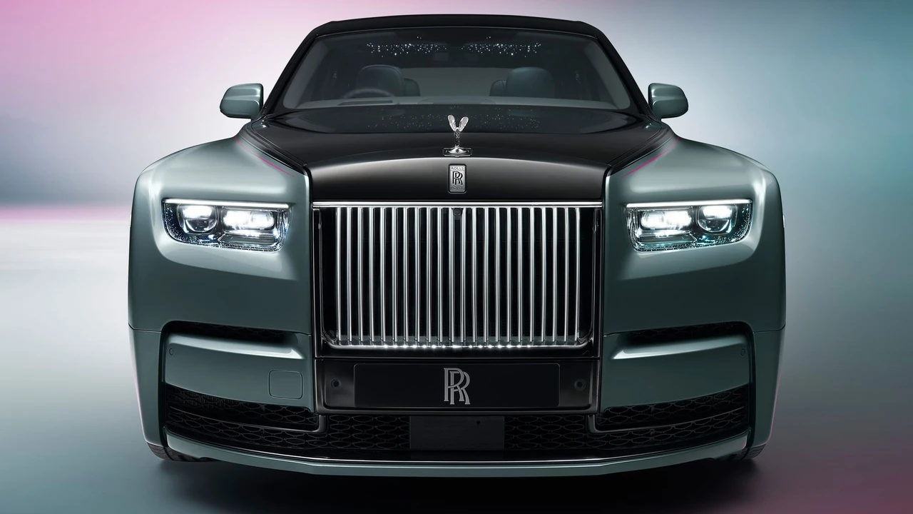 Тёмный Rolls-Royce припаркован на газоне у исторического здания